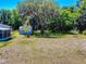 A serene backyard featuring mature trees and a storage shed, perfect for outdoor activities at 242 Cypress Ave, Oak Hill, FL 32759