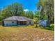 View of backyard with a single-Gathering home, screened-in patio and storage shed at 242 Cypress Ave, Oak Hill, FL 32759