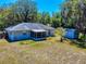 A backyard featuring a home with screened-in patio, storage shed and ample backyard space at 242 Cypress Ave, Oak Hill, FL 32759