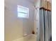 This bathroom features a tiled shower with a window and a blue patterned curtain for a clean and functional space at 242 Cypress Ave, Oak Hill, FL 32759