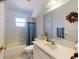 Clean bathroom with a vanity, toilet, shower-tub, and a decorative touch with a wreath at 242 Cypress Ave, Oak Hill, FL 32759