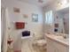 Bright bathroom with a pink sink, white toilet, and decorative butterfly shower curtain at 242 Cypress Ave, Oak Hill, FL 32759