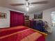 Cozy bedroom featuring red and gold bedding, ceiling fan, and traditional decor at 242 Cypress Ave, Oak Hill, FL 32759