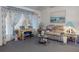 Bright living room with carpet, large windows, and comfortable seating area at 242 Cypress Ave, Oak Hill, FL 32759