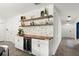 Elegant bar area featuring white cabinets, wooden shelves, mosaic backsplash, and a beverage cooler at 2516 Hoptree Ln, Edgewater, FL 32141