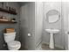 Stylish powder room featuring floating shelves, a pedestal sink, and elegant gray wainscoting at 2516 Hoptree Ln, Edgewater, FL 32141