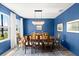 Bright dining room boasts a statement chandelier, bold blue walls, and large windows for abundant natural light at 2516 Hoptree Ln, Edgewater, FL 32141