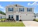 Charming two-story home featuring blue shutters, a manicured lawn, and a two-car garage at 2516 Hoptree Ln, Edgewater, FL 32141