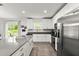 Well-lit kitchen with stainless steel appliances, dark countertops, wooden floors, and sliding glass doors at 2516 Hoptree Ln, Edgewater, FL 32141