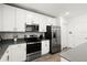 Bright kitchen with white cabinetry, stainless appliances, gray countertops, and stainless fixtures at 2516 Hoptree Ln, Edgewater, FL 32141