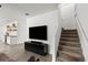 Spacious living room with a wall-mounted television, wood floors, a beverage bar, and a staircase at 2516 Hoptree Ln, Edgewater, FL 32141