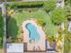 Aerial view of a private backyard oasis featuring a kidney-shaped pool, manicured lawn, and lush landscaping at 2548 E Compton St, Orlando, FL 32806