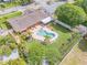 Aerial view of a backyard with a pool, spa, lush landscaping, and fenced yard at 2548 E Compton St, Orlando, FL 32806