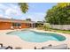 Inviting backyard with a sparkling pool, relaxing hot tub, screened patio, and well-manicured landscaping at 2548 E Compton St, Orlando, FL 32806