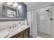Bathroom featuring a modern vanity, shower with white subway tile, blue accent wall and framed mirror at 2548 E Compton St, Orlando, FL 32806