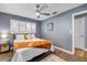 Inviting bedroom with a ceiling fan, wood-look flooring, and shuttered windows at 2548 E Compton St, Orlando, FL 32806