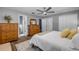 Comfortable bedroom with wood floors, ceiling fan, dresser, large bed and en suite bathroom at 2548 E Compton St, Orlando, FL 32806