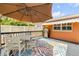 Outdoor deck with a dining set, barbecue grill, colorful rug, and a retractable awning for comfortable outdoor entertaining at 2548 E Compton St, Orlando, FL 32806