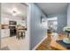 Bright hallway view to the kitchen with white cabinets and black appliances at 2548 E Compton St, Orlando, FL 32806