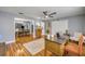 Inviting home office with hardwood floors, ceiling fan, and a view into the open dining and kitchen areas at 2548 E Compton St, Orlando, FL 32806