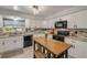 Lovely kitchen boasting white cabinets, granite countertops, modern appliances, island seating and bright lighting at 2548 E Compton St, Orlando, FL 32806