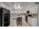 Stylish kitchen featuring white cabinetry, granite countertops, stainless appliances, island seating and tile flooring at 2548 E Compton St, Orlando, FL 32806