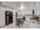 Open kitchen with white cabinets, stainless steel appliances, island seating and tile floors at 2548 E Compton St, Orlando, FL 32806