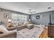 Comfortable living room featuring a sectional sofa, ceiling fan, and large windows with plantation shutters at 2548 E Compton St, Orlando, FL 32806
