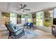 Bright sunroom surrounded with large windows, comfortable seating, ceiling fan and backyard views at 2548 E Compton St, Orlando, FL 32806