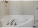 Relaxing bathroom featuring a sizable soaking tub with chrome fixtures and white tiled surround at 2713 Needle Palm Dr, Edgewater, FL 32141