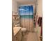 Functional bathroom with a combination shower and tub, storage shelving, and a well-lit vanity area at 2725 Travelers Palm Dr, Edgewater, FL 32141