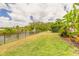 Spacious backyard with a manicured lawn, fenced perimeter, and a picturesque view of the pond and fountain at 2913 Linari Ct, New Smyrna Beach, FL 32168