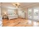 Bright main bedroom featuring hardwood floors, a ceiling fan, and access to the screened pool area at 2913 Linari Ct, New Smyrna Beach, FL 32168