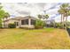Expansive property featuring a well-maintained lawn, screened-in patio, and a pool area surrounded by palm trees at 2913 Linari Ct, New Smyrna Beach, FL 32168