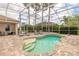 Inviting screened-in pool area with lounge chairs, lush landscaping, and a serene atmosphere for relaxation at 2913 Linari Ct, New Smyrna Beach, FL 32168