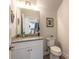Half bathroom with granite vanity and a decorative mirror at 3136 Portofino Blvd, New Smyrna Beach, FL 32168