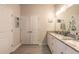 Bathroom featuring double sinks with granite countertops, white cabinets, and a large mirror at 3136 Portofino Blvd, New Smyrna Beach, FL 32168