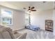 Bedroom with a ceiling fan, carpeted floor, bookcase, and two windows at 3136 Portofino Blvd, New Smyrna Beach, FL 32168
