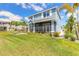 Stunning two-story home with a screened-in porch, beautiful landscaping, and a green lawn at 3136 Portofino Blvd, New Smyrna Beach, FL 32168