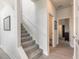 Carpeted staircase leading to the upper level of the home, with wood flooring in the hallway at 3136 Portofino Blvd, New Smyrna Beach, FL 32168