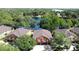 Aerial view of a two-story orange home with a two-car garage, set near a tranquil lake surrounded by trees at 3311 Pine Oak Trl, Sanford, FL 32773