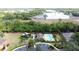 Aerial view of the community pool and playground surrounded by lush landscaping and brick perimeter wall at 3311 Pine Oak Trl, Sanford, FL 32773