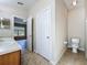 This secondary bathroom area features a sink/vanity, toilet and doorway to the Primary bedroom at 3311 Pine Oak Trl, Sanford, FL 32773