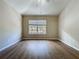 This bedroom has a neutral wall color, wood-look floors and a double window with exterior views at 3311 Pine Oak Trl, Sanford, FL 32773