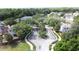 Wide aerial shot of a community entrance with a circular median, framed by brick fencing and mature trees at 3311 Pine Oak Trl, Sanford, FL 32773
