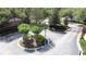 Aerial view of a gated community entrance featuring mature landscaping, a circular median, and brick fencing at 3311 Pine Oak Trl, Sanford, FL 32773