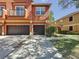 Exterior view of townhomes with a two-car garage, small balcony, and well-maintained landscaping at 3311 Pine Oak Trl, Sanford, FL 32773