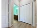 This hallway features wood-look floors, a linen closet and a bathroom with green wall color at 3311 Pine Oak Trl, Sanford, FL 32773
