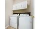 Bright laundry room with white washer and dryer and above-appliance storage at 3311 Pine Oak Trl, Sanford, FL 32773