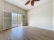 Bright living area with wood-look floors, ceiling fan, and sliding doors to a balcony at 3311 Pine Oak Trl, Sanford, FL 32773
